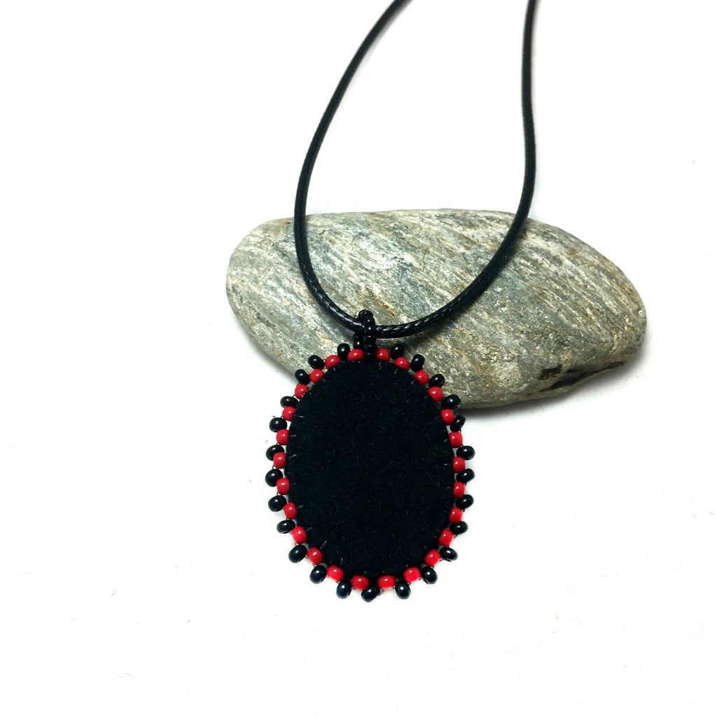 Back of red crown raven beaded pendant