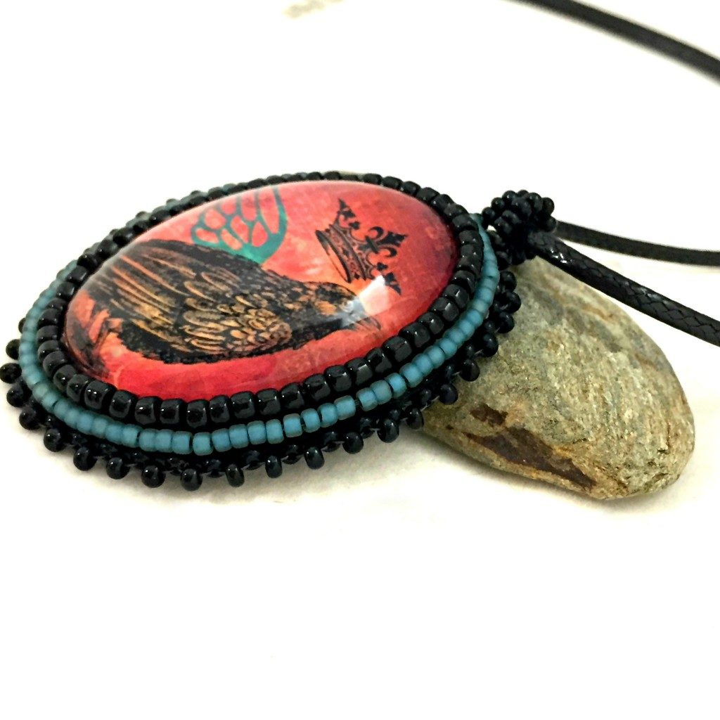 Side shot of raven with teal wing pendant