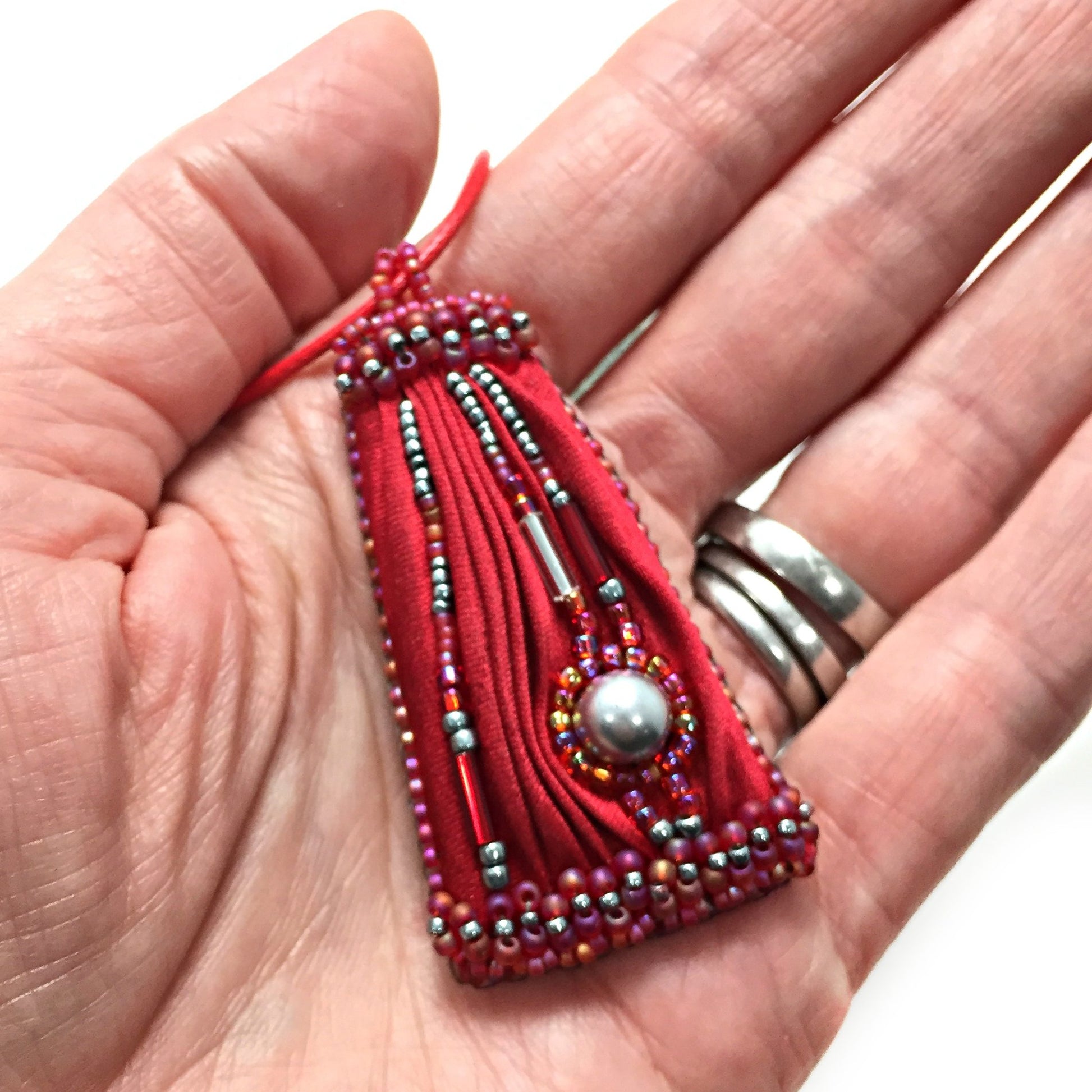 red silk pendant in hand