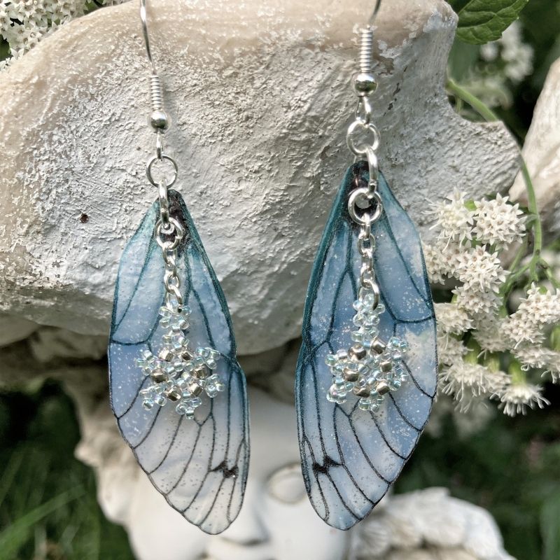 Close up of Blue Ice fairy wing earrings with beaded snowflake charms