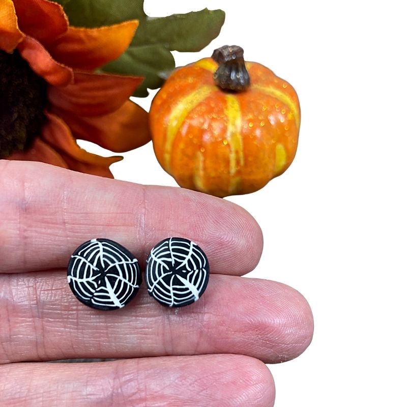 spiderweb earrings in hand