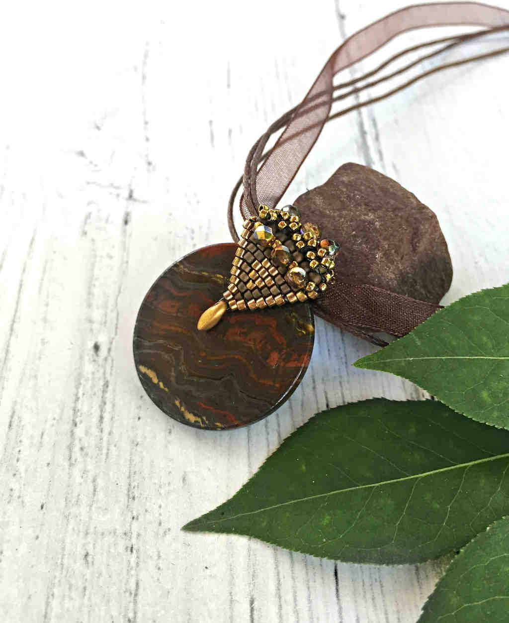 elegant tigers eye pendant with elaborate beaded gold bail