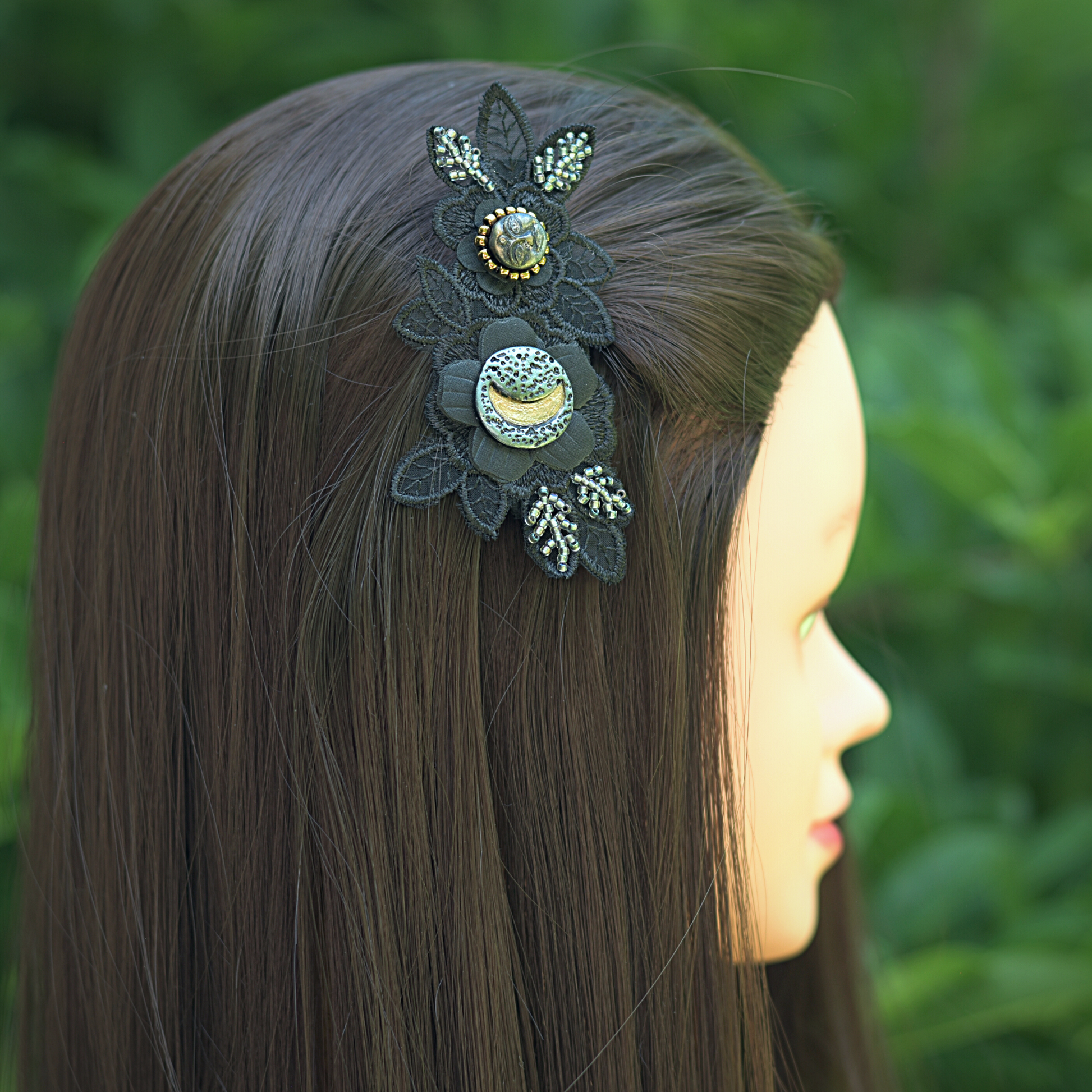 Black applique flower beaded with silver and gold beads with a crescent moon and a full face moon focal cabochons in the hair of a model