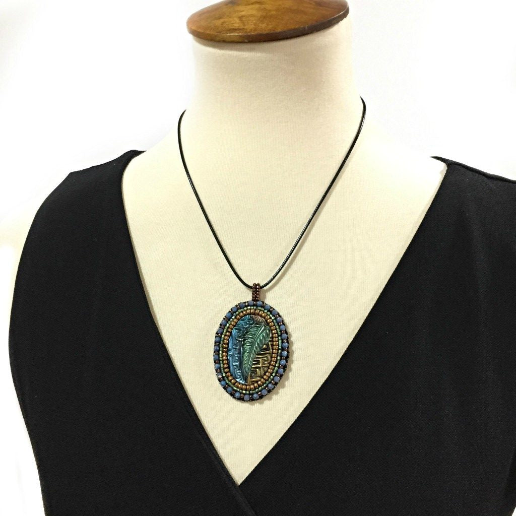 zentangle art pendant with blue crystals on mannequin